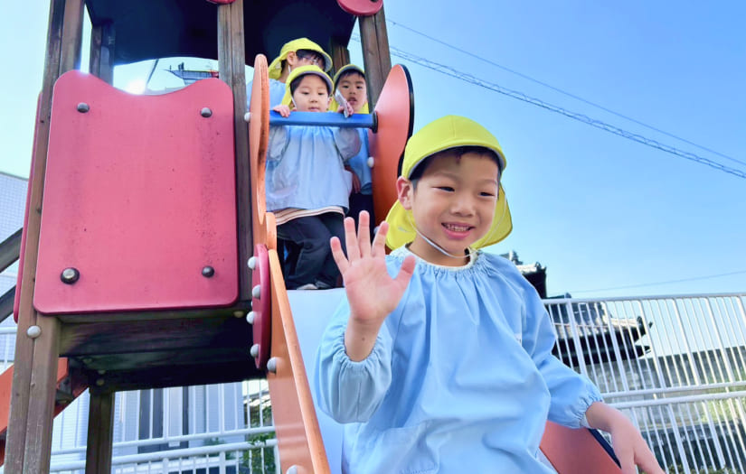 カラフルな大型遊具（滑り台）で元気に遊ぶ園児