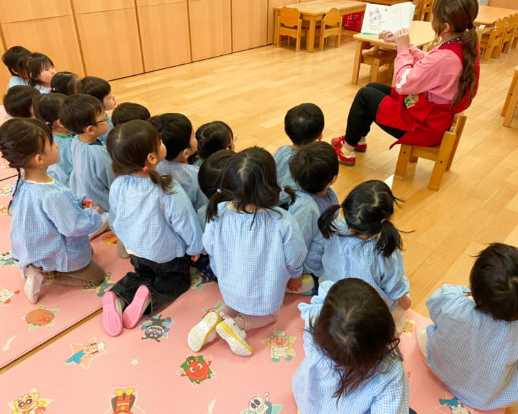 先生と一緒に歌や手遊びを楽しむ音楽教育の風景