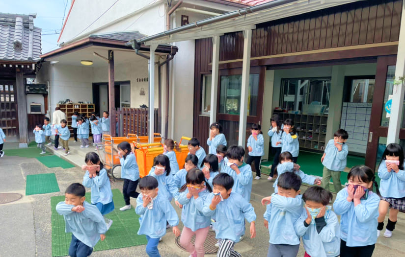 ハンカチで口を押えながら、安全に園庭へ避難する訓練の様子